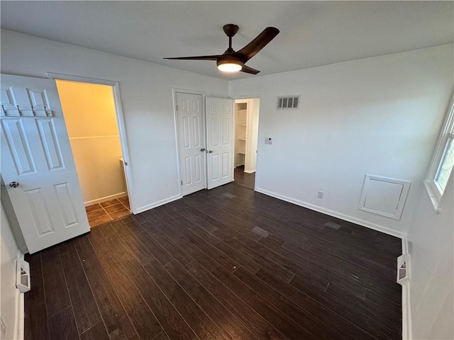 unfurnished bedroom featuring ceiling fan and dark wood-type flooring