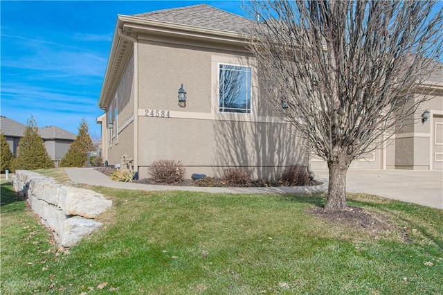 view of side of home with a garage and a lawn