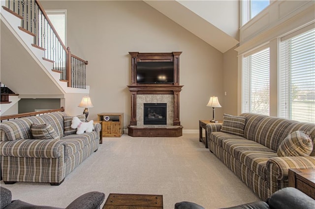 living room with carpet flooring, a premium fireplace, and a high ceiling