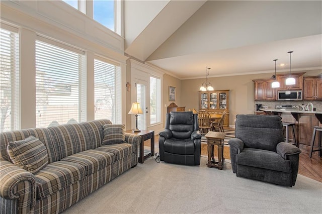 living room featuring crown molding, a chandelier, and a high ceiling