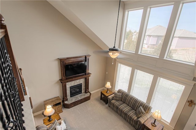 carpeted living room with ceiling fan and a high end fireplace