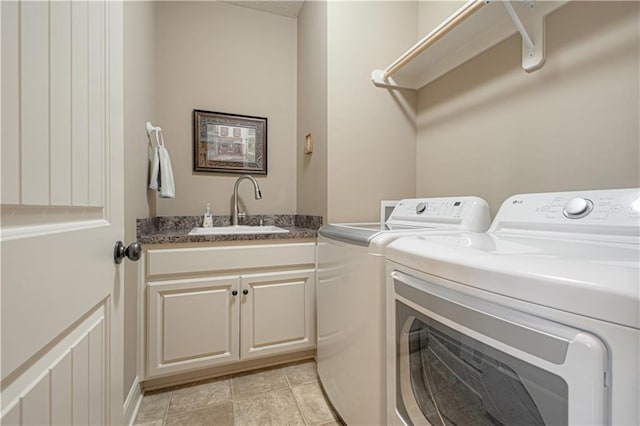 washroom with cabinets, light tile patterned flooring, sink, and washer and clothes dryer