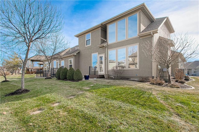 rear view of house featuring a lawn