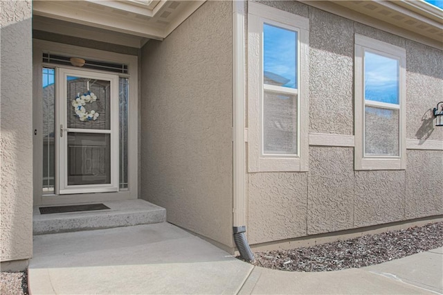 entrance to property featuring stucco siding