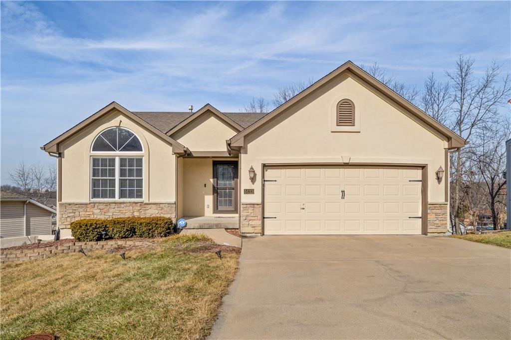 ranch-style house featuring a garage and a front yard