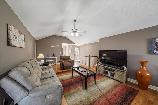 living room featuring ceiling fan, vaulted ceiling, and wood-type flooring