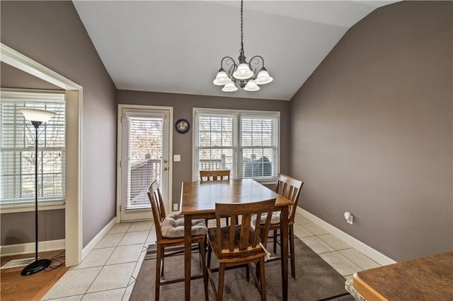 tiled dining space with vaulted ceiling and a notable chandelier