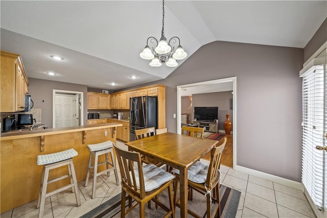 dining room with light tile patterned floors, a notable chandelier, and vaulted ceiling