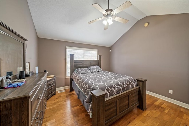 bedroom with ceiling fan, lofted ceiling, and light wood-type flooring