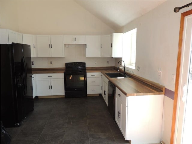 kitchen featuring dark tile patterned flooring, a sink, wood counters, white cabinets, and black appliances