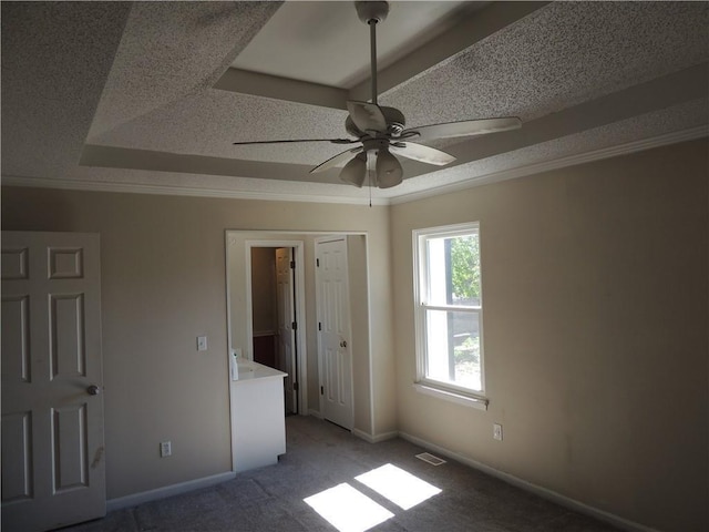 unfurnished bedroom featuring visible vents, baseboards, ornamental molding, carpet, and a textured ceiling