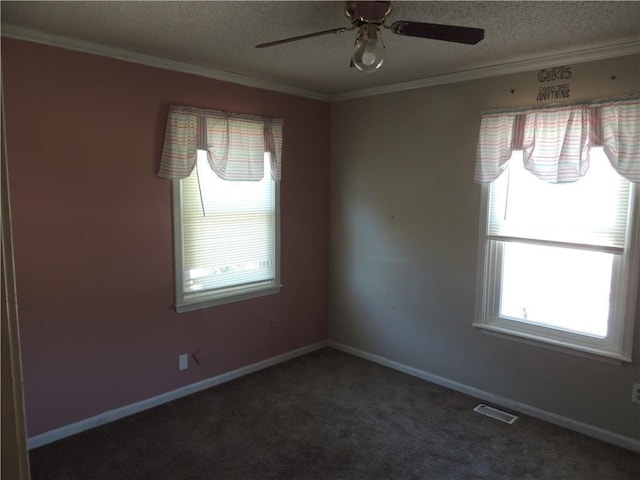 spare room with dark colored carpet, visible vents, crown molding, and a textured ceiling