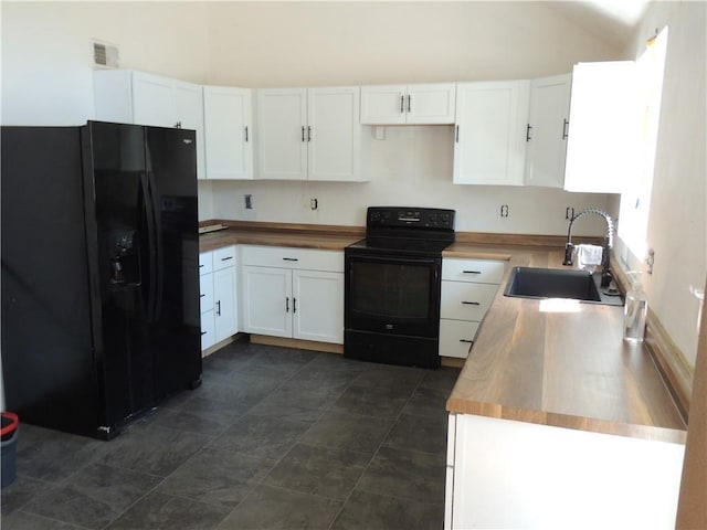 kitchen featuring lofted ceiling, visible vents, white cabinetry, a sink, and black appliances