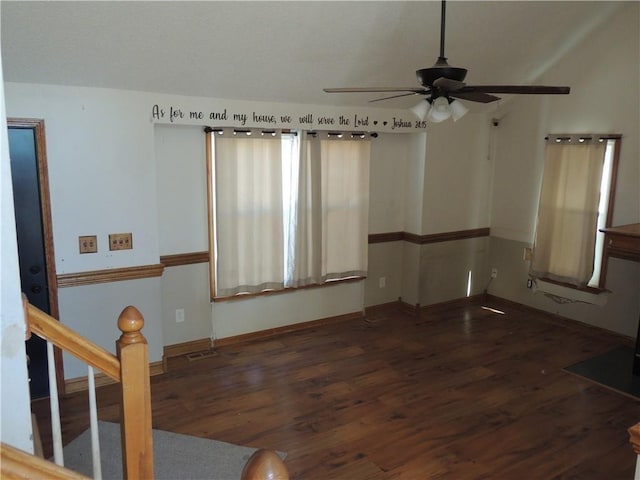 empty room featuring dark wood-type flooring, baseboards, and a ceiling fan