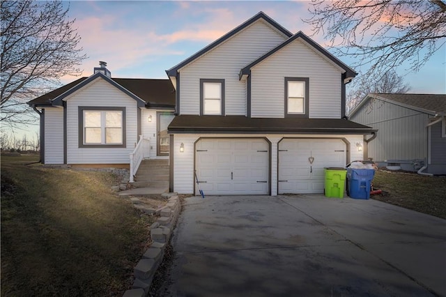 tri-level home featuring an attached garage and driveway