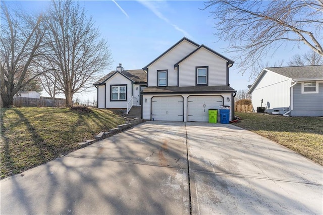 tri-level home featuring concrete driveway, an attached garage, and a front yard