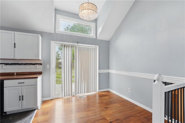 2016 NE Summerfield Ct, Blue Springs, MO 64029 - unfurnished dining area with lofted ceiling, a chandelier, and light wood-style floors