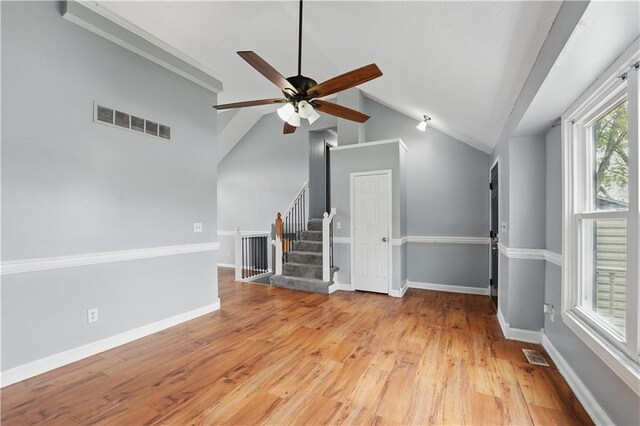2016 NE Summerfield Ct, Blue Springs, MO 64029 - unfurnished living room featuring stairway, lofted ceiling, a ceiling fan, and light wood-type flooring