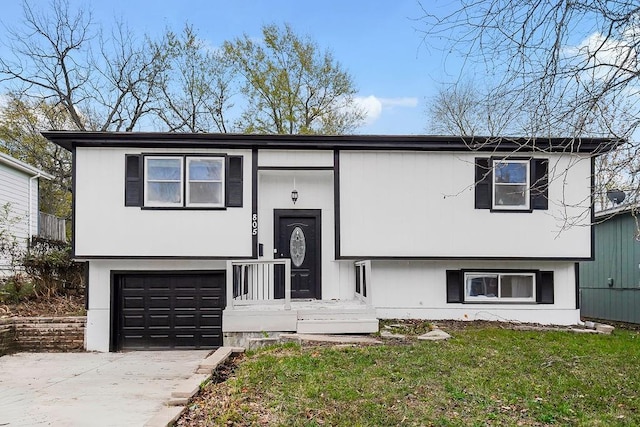 split foyer home with a garage and a front lawn