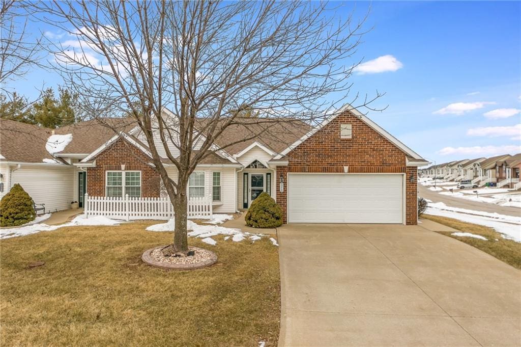 ranch-style house with a garage and a front lawn