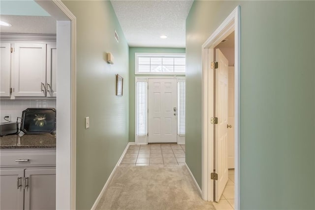 foyer featuring light tile patterned floors and a textured ceiling