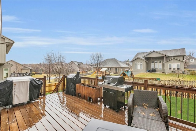 wooden terrace with a yard, a residential view, and a grill