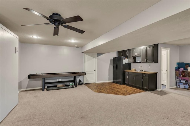 interior space with carpet floors, baseboards, a sink, and freestanding refrigerator