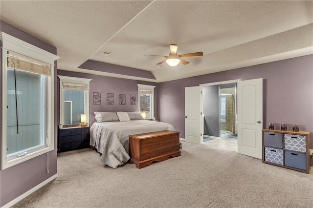 carpeted bedroom featuring baseboards, visible vents, a raised ceiling, and a textured ceiling