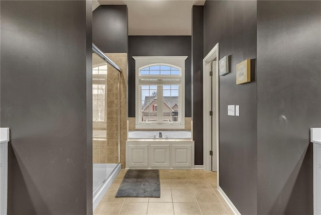 full bathroom featuring a garden tub, a shower stall, and tile patterned floors