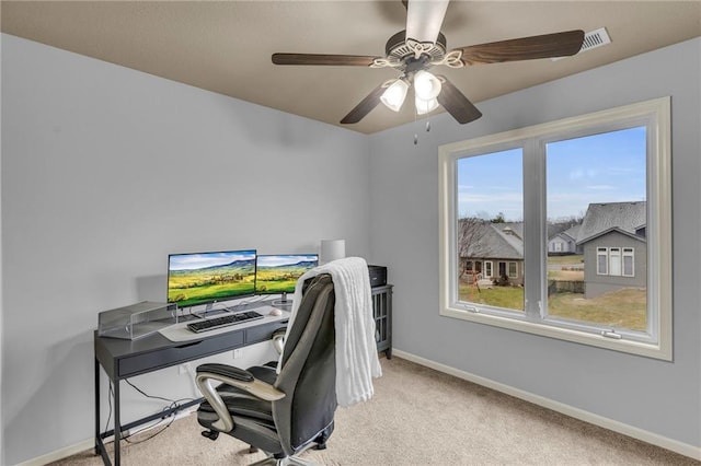 office space featuring carpet floors, baseboards, and a ceiling fan