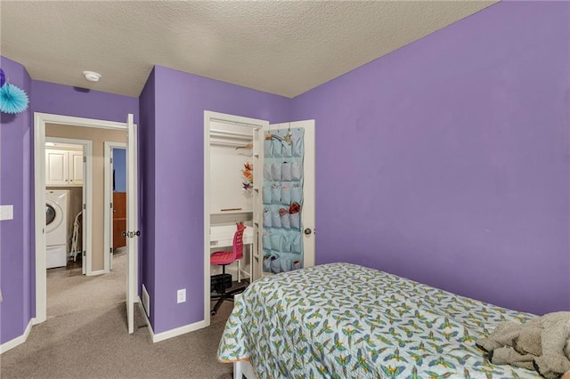 carpeted bedroom featuring washer / clothes dryer, a textured ceiling, and baseboards