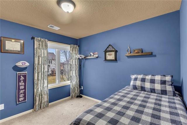 unfurnished bedroom with carpet, a textured ceiling, visible vents, and baseboards