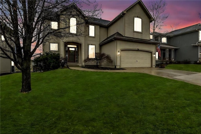 traditional home with a garage, a lawn, driveway, and stucco siding