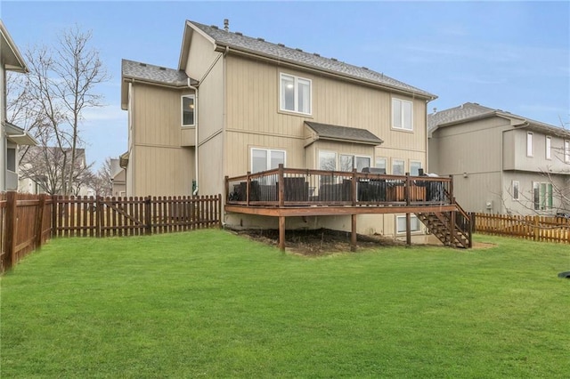 back of property with a deck, a yard, a fenced backyard, and stairs