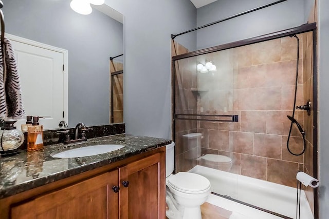 bathroom featuring vanity, toilet, and an enclosed shower