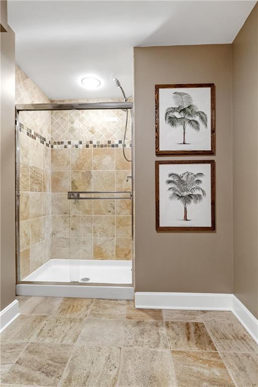 bathroom with a stall shower and baseboards