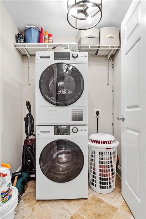 clothes washing area with laundry area and stacked washer / drying machine