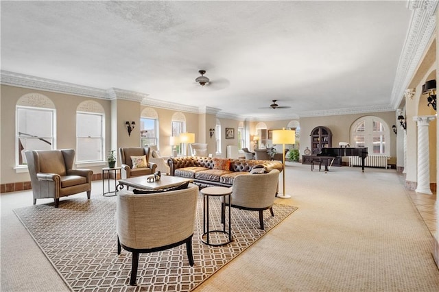 living area with ornate columns, ceiling fan, ornamental molding, and light colored carpet