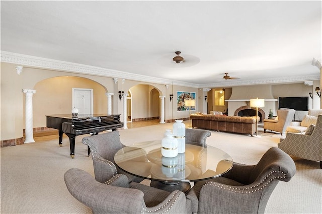 dining space featuring ornate columns, arched walkways, crown molding, and light colored carpet