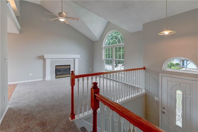 828 SW Harvest Dr, Grain Valley, MO 64029 - carpeted entrance foyer featuring ceiling fan, healthy amount of natural light, a tile fireplace, baseboards, and high vaulted ceiling