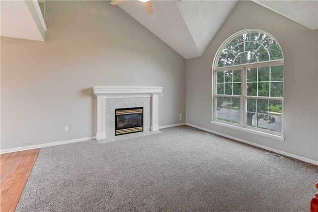 828 SW Harvest Dr, Grain Valley, MO 64029 - unfurnished living room with ceiling fan, a fireplace, baseboards, high vaulted ceiling, and carpet floors