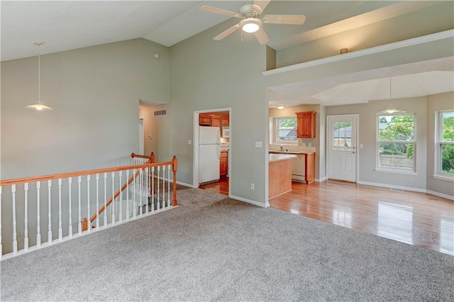 828 SW Harvest Dr, Grain Valley, MO 64029 - spare room with light colored carpet, ceiling fan, baseboards, high vaulted ceiling, and a sink