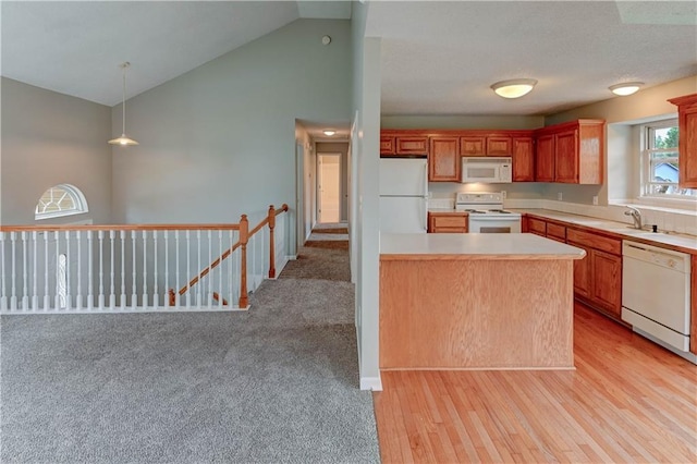 828 SW Harvest Dr, Grain Valley, MO 64029 - kitchen with white appliances, light countertops, vaulted ceiling, light wood-type flooring, and pendant lighting