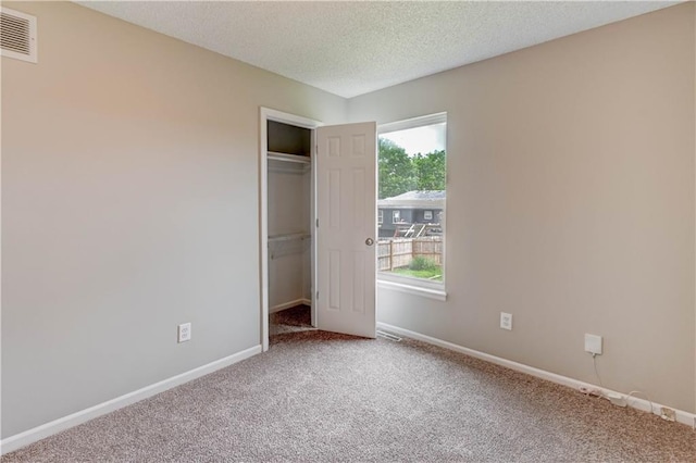 828 SW Harvest Dr, Grain Valley, MO 64029 - unfurnished bedroom featuring light carpet, baseboards, a closet, and a textured ceiling