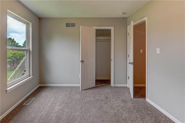 828 SW Harvest Dr, Grain Valley, MO 64029 - unfurnished bedroom featuring carpet, a textured ceiling, a closet, and baseboards