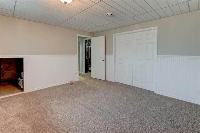 828 SW Harvest Dr, Grain Valley, MO 64029 - unfurnished bedroom featuring a wainscoted wall, carpet, and a closet