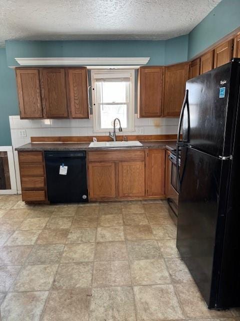 kitchen featuring black appliances, a textured ceiling, and sink