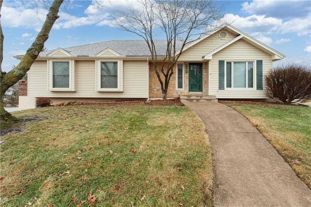 single story home featuring a front lawn