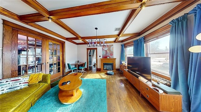 living room featuring coffered ceiling, hardwood / wood-style floors, beam ceiling, and french doors