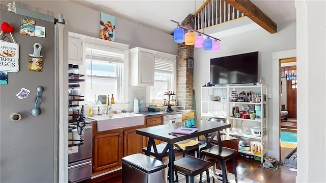 bar featuring stainless steel refrigerator, beamed ceiling, white cabinetry, sink, and range